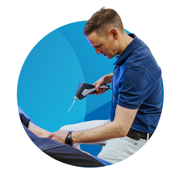 A specialist performing cryotherapy on a patient in a treatment room.