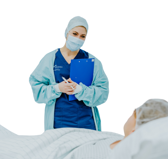 A surgical assistant speaking calmly with a patient before the operation, offering reassurance and support.